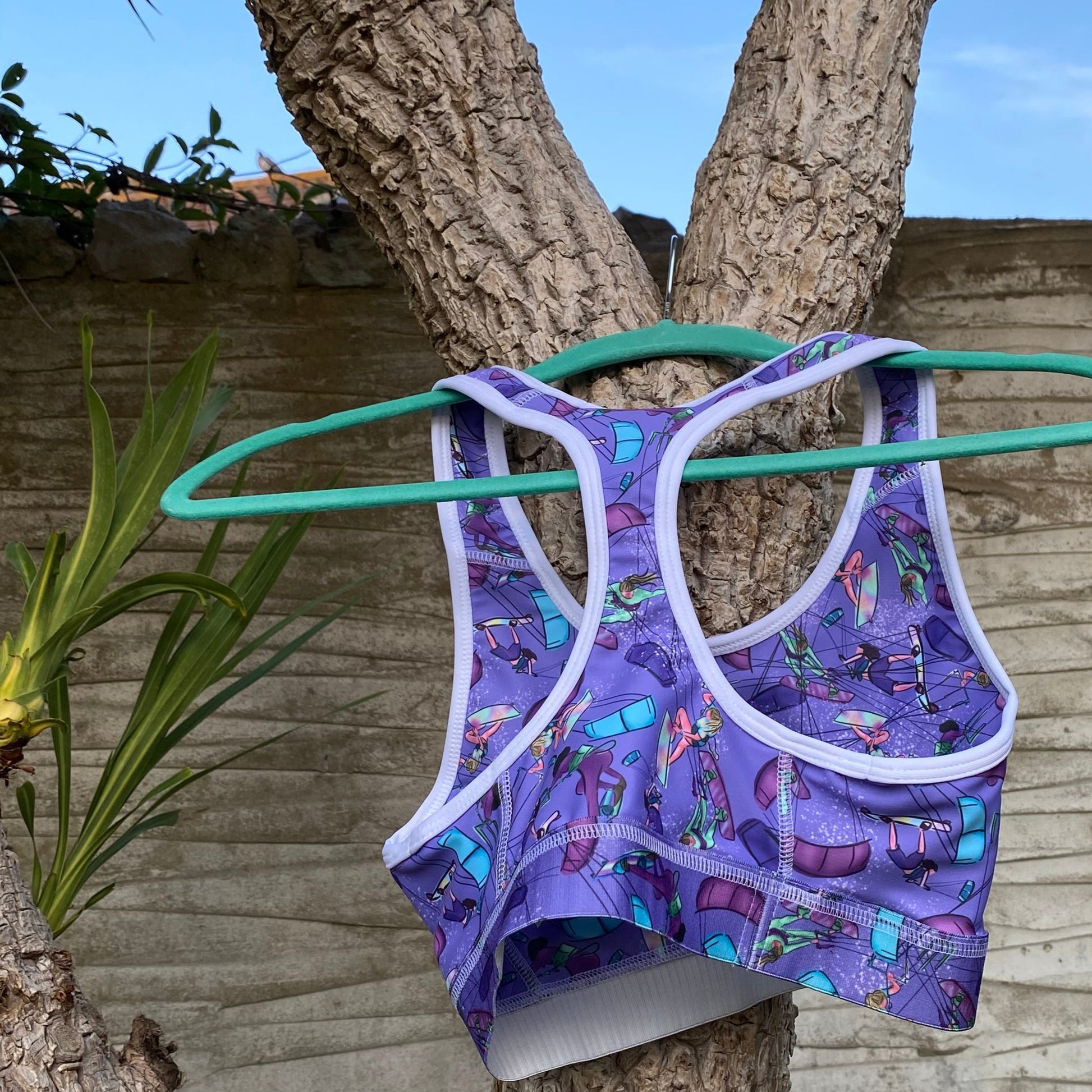 Purple sports bra hanging on a palm tree