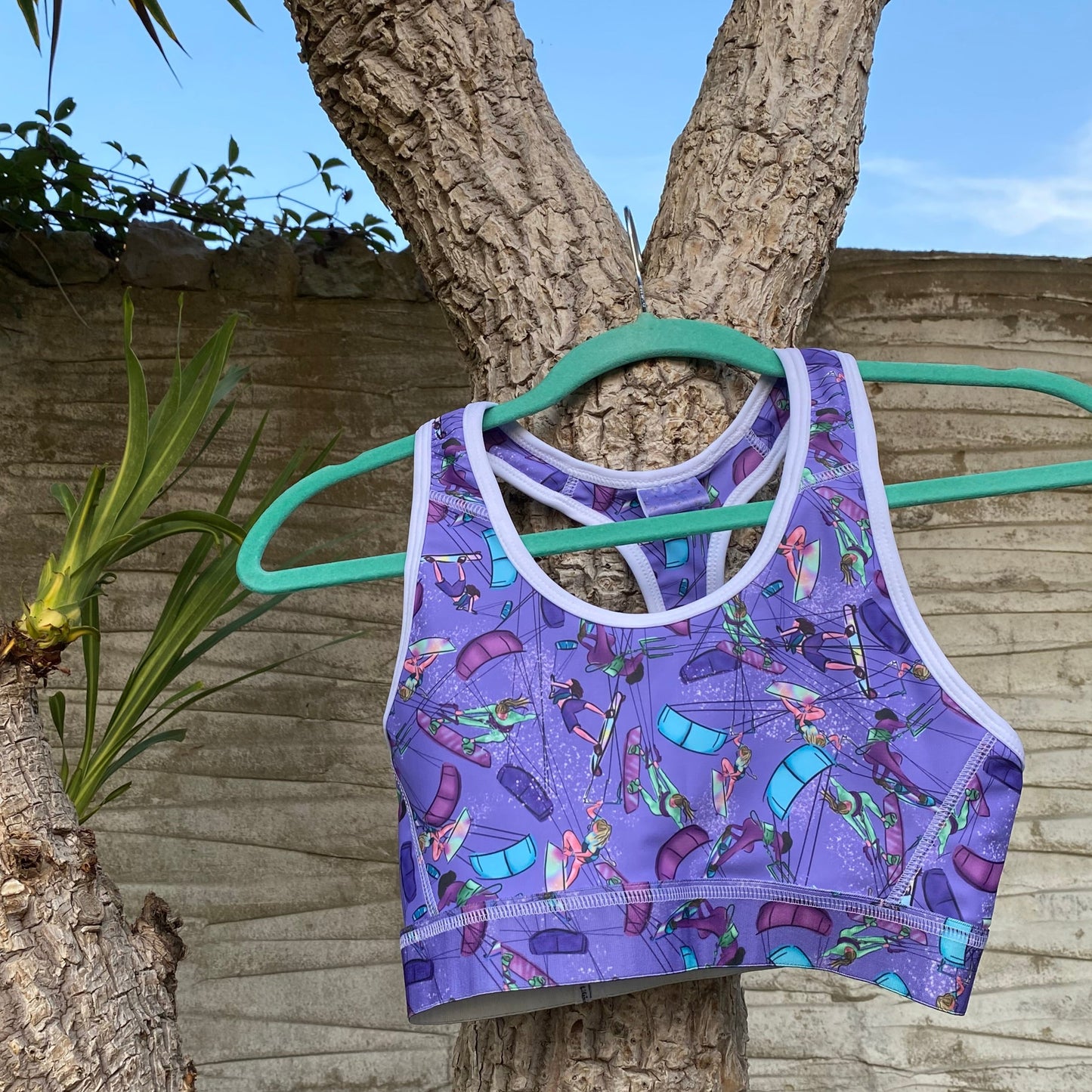 Purple sports bra hanging on a palm tree